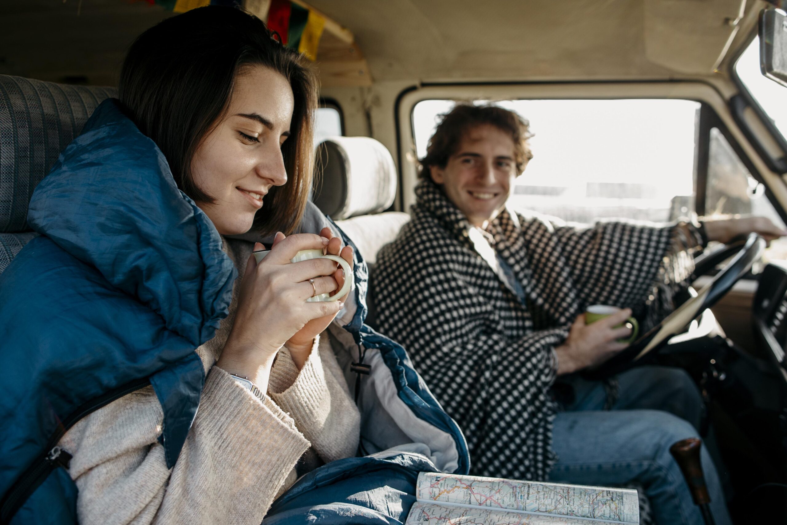 Young couple enjoying a road trip while driving a vehicle, representing beginner driver experience and driving practice.